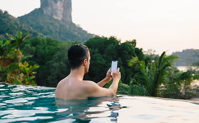 Hombre usando su teléfono en una piscina