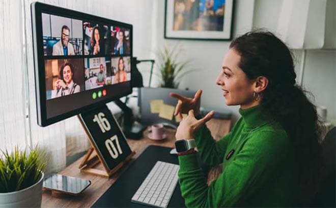 Woman working from home and videoconferencing with several colleagues.