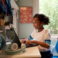 young girl at computer with headphones