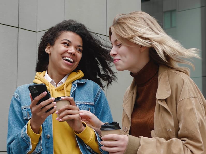 mujer sosteniendo un teléfono y sonriendo