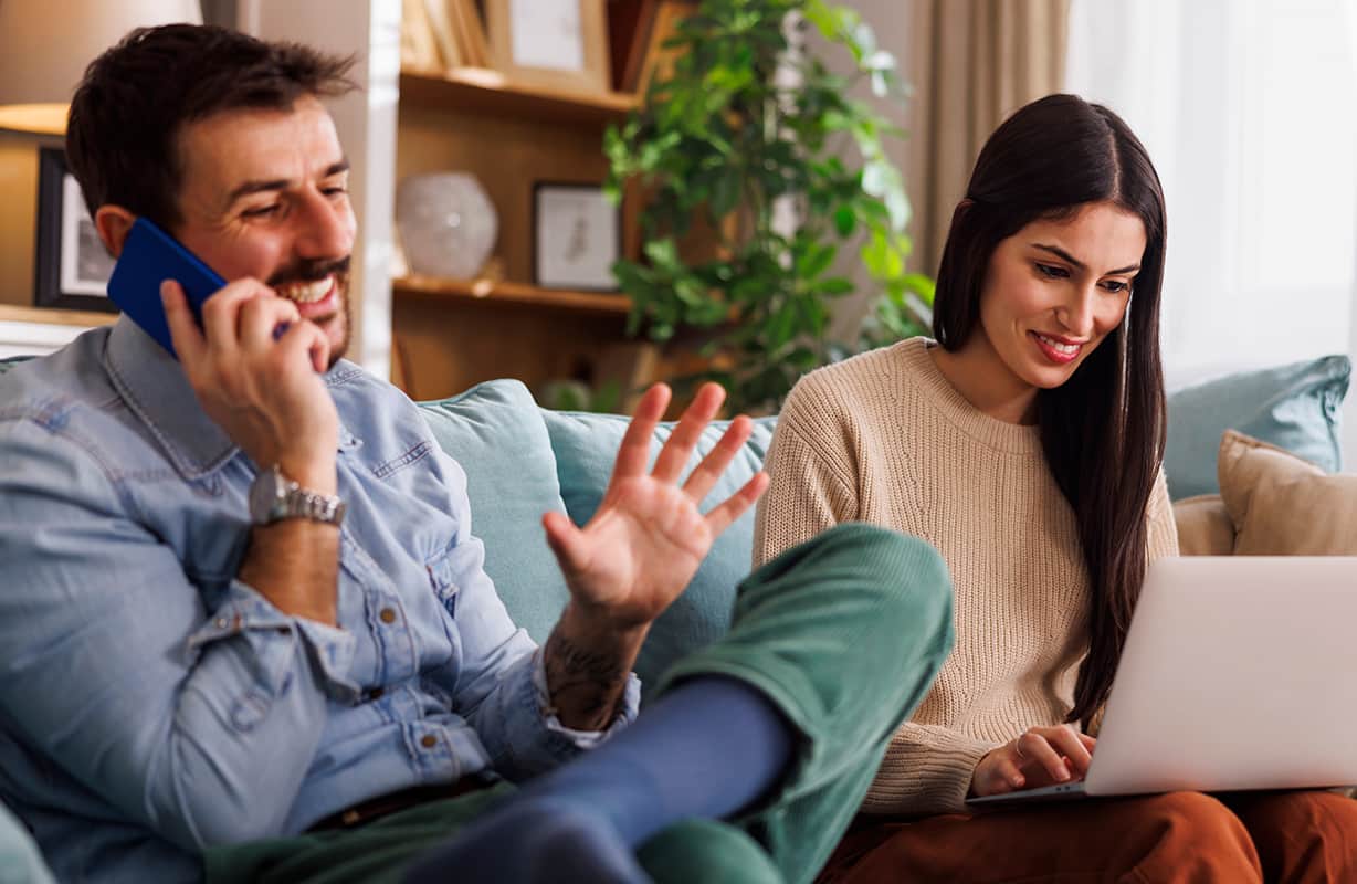Man talking on phone, women watching laptop