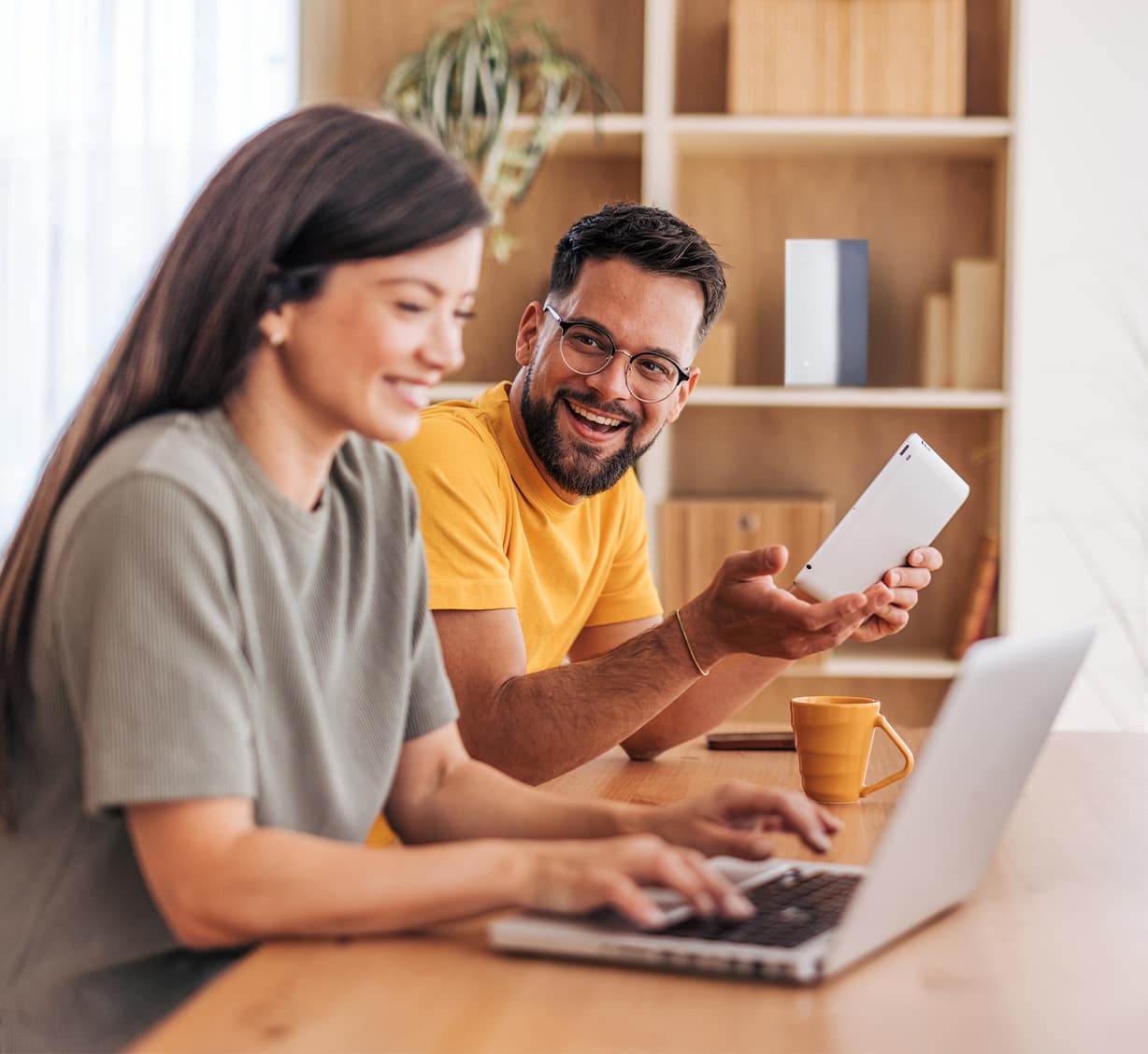 man and woman at table with laptop and phone
