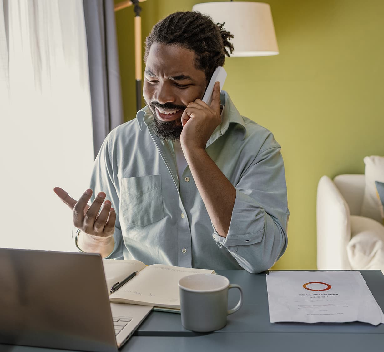 Imagen de un hombre hablando por teléfono con una laptop en el escritorio