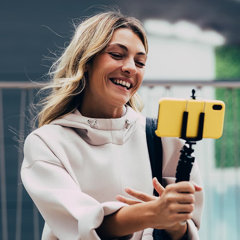 Creadora de contenido filmándose con un smartphone