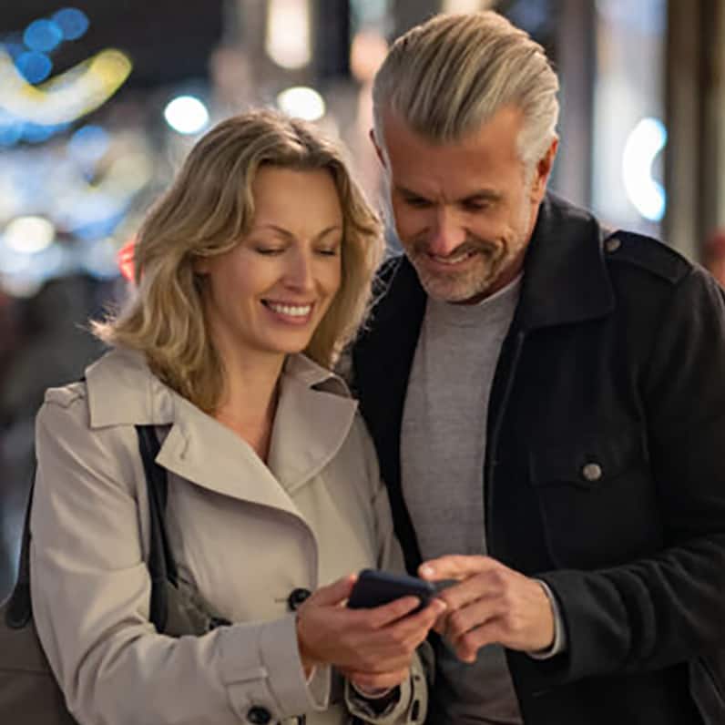 Persona sentada en una silla mirando un teléfono móvil
