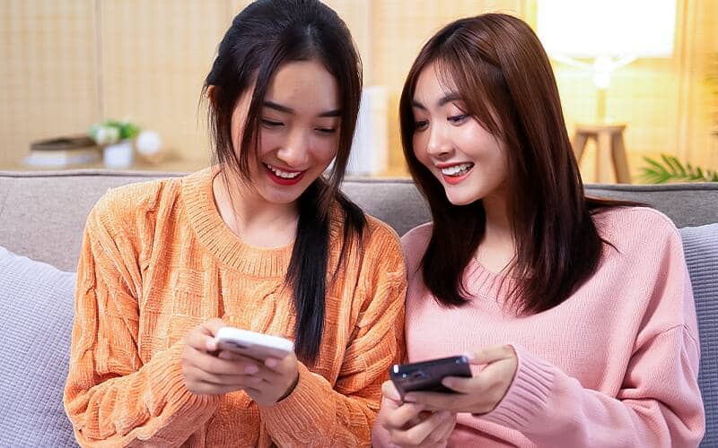 Two ladies looking to smartphone