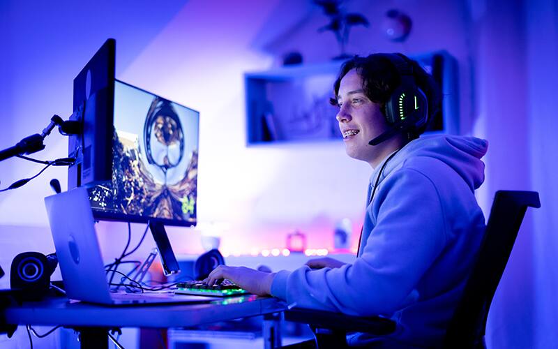Mujer mirando una computadora de escritorio y sonriendo
