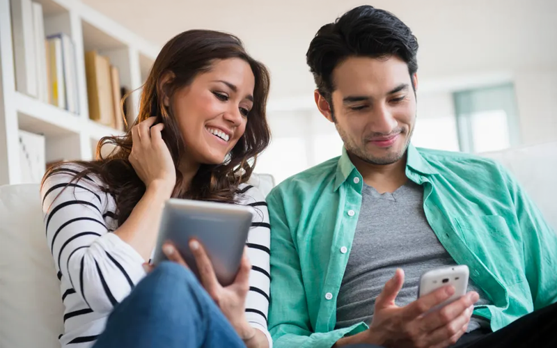  A girl with smiling face looking at her phone and typing