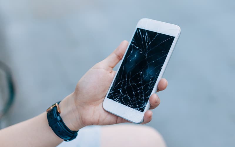 Una persona mirando un móvil dañado