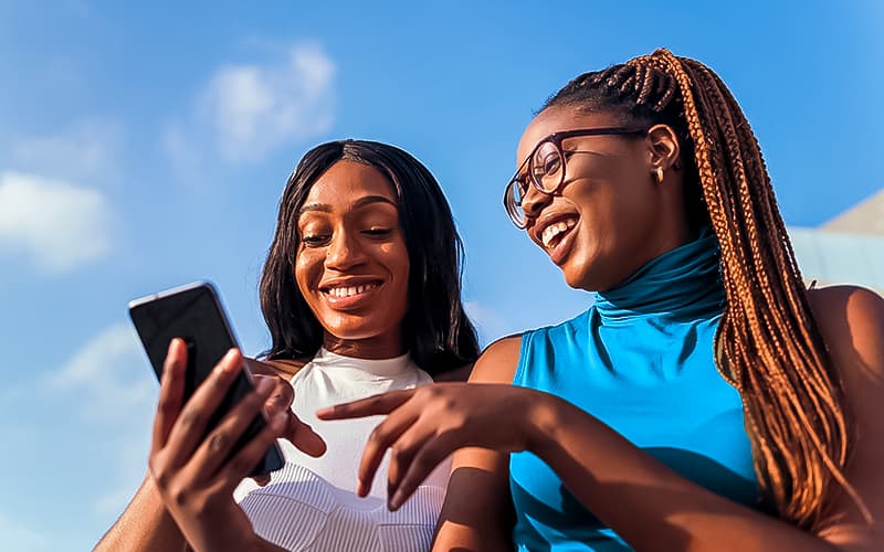 two ladies looking to smartphone